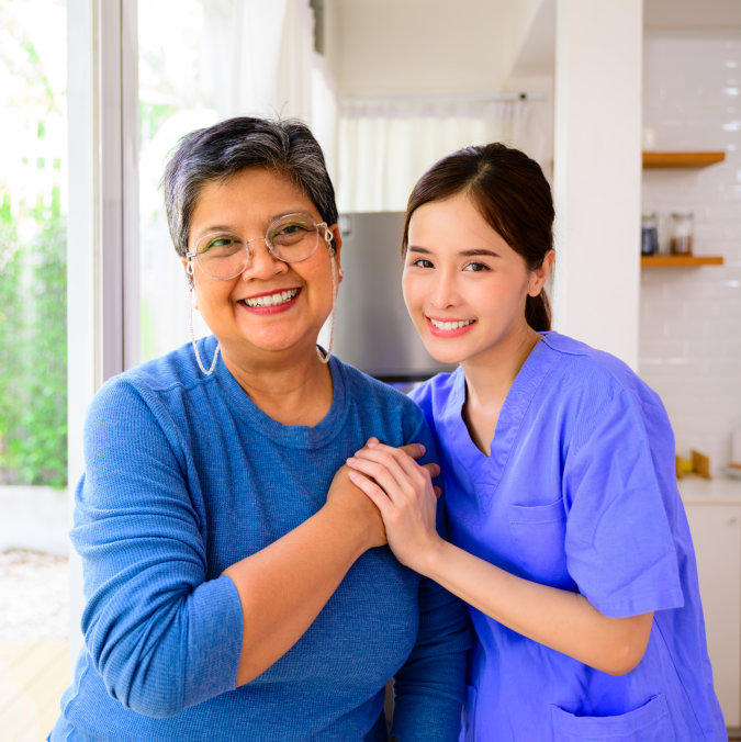 aide and senior woman smiling