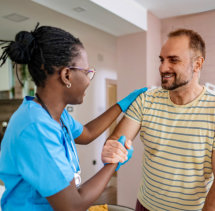 senior man smiling at aide