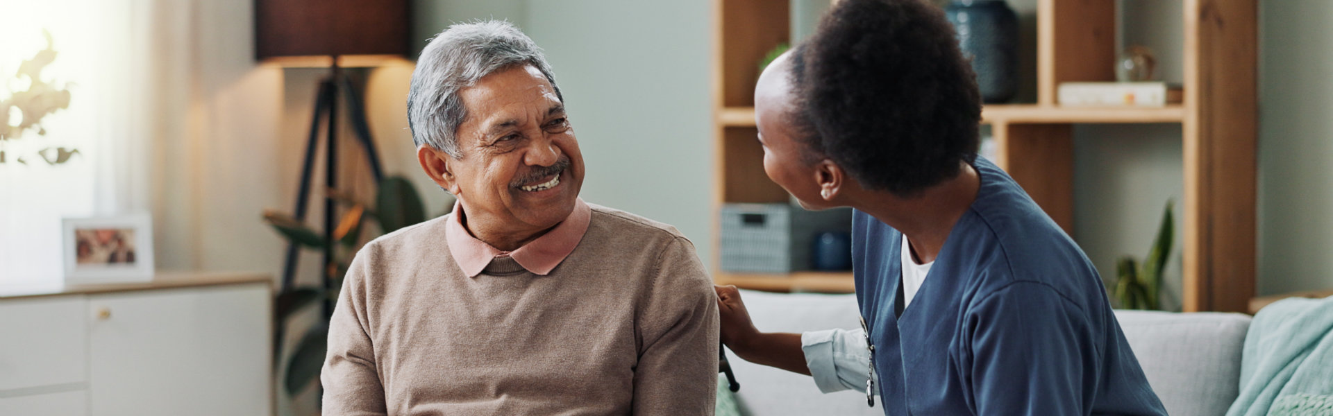 senior man smiling at aide